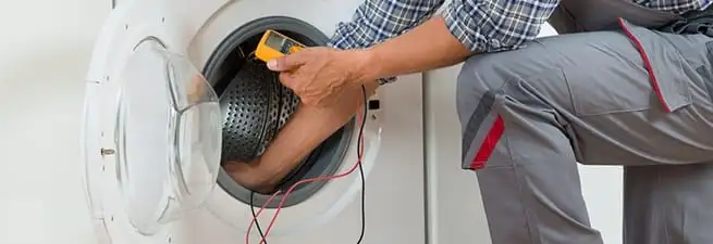 Dryer repair technician inspecting and repairing a clothes dryer in Pasadena, CA