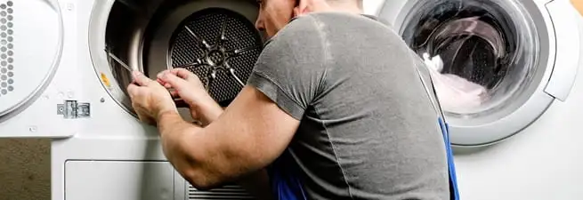Dryer repair technician fixing a clothes dryer drum in Pasadena, CA