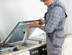Appliance repair technician installing a built-in cooktop in Pasadena, CA