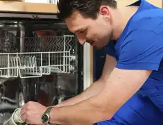 Dishwasher repair technician inspecting and servicing an open dishwasher in Pasadena, CA