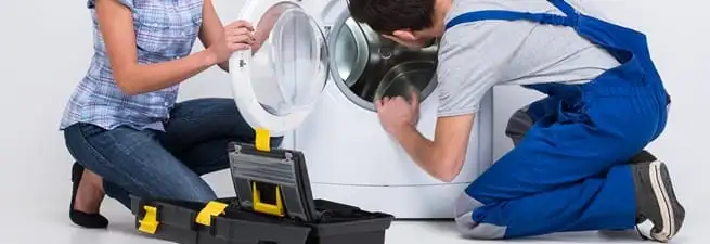 Washer repair technician inspecting a front-load washing machine with tools in Pasadena, CA