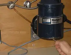 Garbage disposal repair technician tightening the mounting ring under a sink in Pasadena, CA