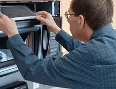 Appliance repair technician replacing a microwave vent filter in Pasadena, CA