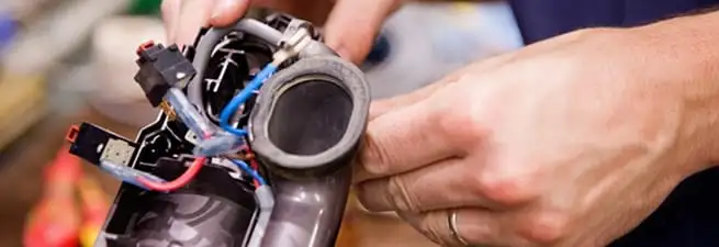 Vacuum repair technician reconnecting wiring and components in Pasadena, CA