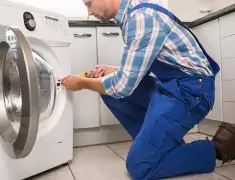 Washing machine repair technician servicing a front-load washer in Pasadena, CA