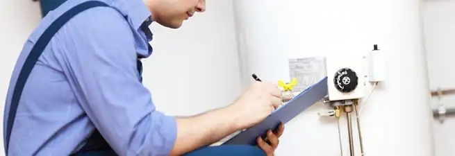 Water heater repair technician inspecting the unit and recording service notes in Pasadena, CA