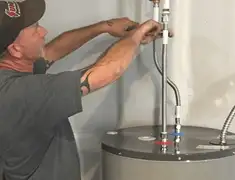 Water heater repair technician tightening supply line connections in Pasadena, CA