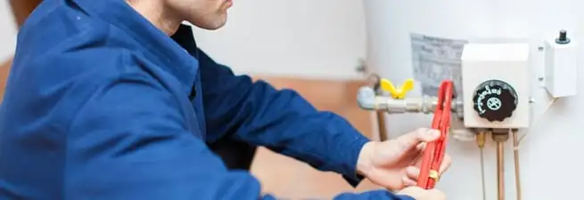 Water heater repair technician adjusting the temperature control and gas valve in Pasadena, CA